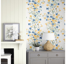Dekoratives Interieur mit Tapete mit Blumenmuster, Kommode, Lampe und Kamin.