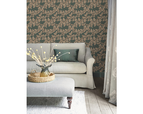 Wohnzimmer mit grüner Blättertapete, Sofa und Ottomane