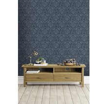 Wohnzimmer mit blau gemusterter Tapete und Holzmöbeln