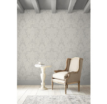 Innenraum mit floral gemusterter Tapete, Sessel und Beistelltisch