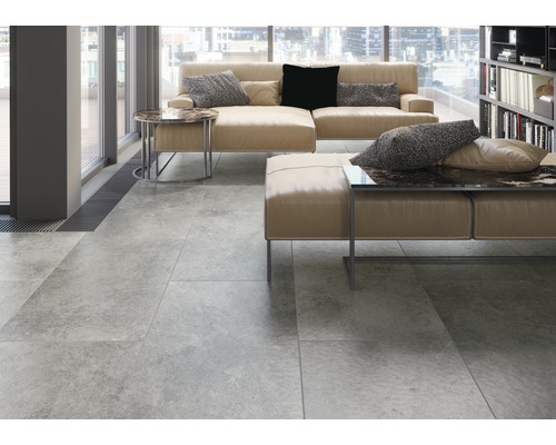 Heller Wohnraum mit Fliesenboden, Sofa und Bücherregal