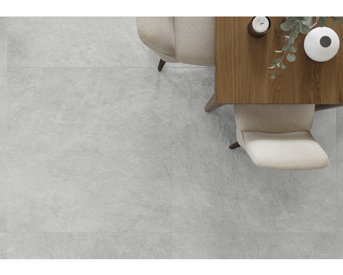 Heller Raum mit Fliesen in Steinoptik, Tisch und Stühlen.