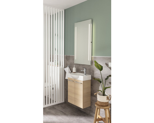 Modernes Badezimmer mit Waschtisch, beleuchtetem Spiegel und Raumteiler