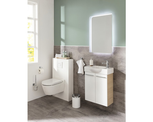 Helles Badezimmer mit Toilette, Waschtischunterschrank und beleuchtetem Spiegel