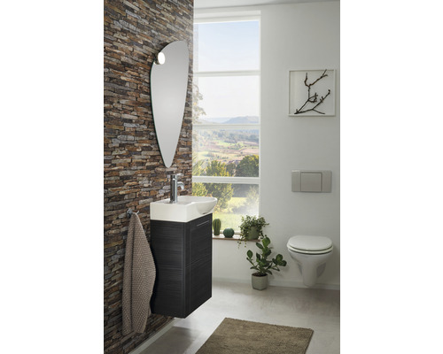 Badezimmer mit Waschtisch, Spiegel und Wand-WC vor einem Fenster