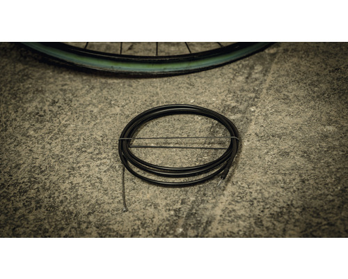 Schwarzer Fahrradbremszug auf Beton