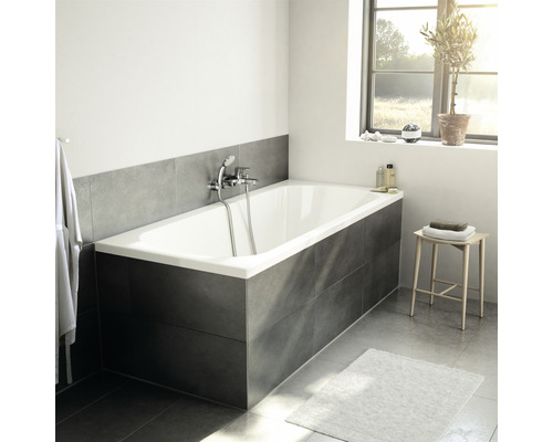 Badezimmer mit Badewanne, Armatur, Hocker und Fenster