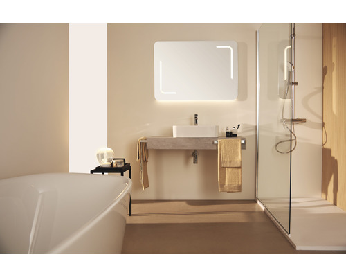 Badezimmer mit Badewanne, Waschtisch, Spiegel mit Beleuchtung und Dusche mit Duschabtrennung.