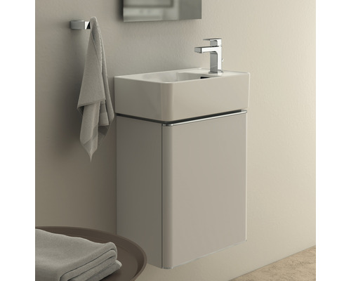 Waschtisch mit Unterschrank, Armatur und Handtuchhalter im Badezimmer.