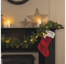 Dekorativer Kamin mit LED-Lichterkette, Tannengirlande, Sternen und Weihnachtssocke für festliche Atmosphäre