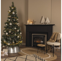 Weihnachtlich dekorierter Wohnraum mit Weihnachtsbaum, Kamin und Teppich