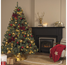 Weihnachtsbaum mit rotem und goldenem Weihnachtsschmuck in einem Wohnzimmer mit Kamin
