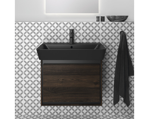 Badezimmer Waschtisch mit Unterschrank und Armatur vor gemusterter Fliesenwand