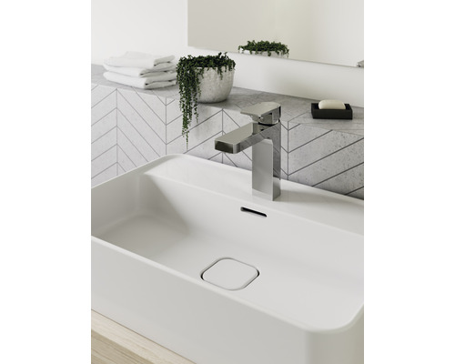 Badezimmerwaschbecken mit Armatur, Seife, Handtüchern und Pflanze