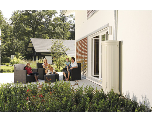 Familie sitzt auf der Terrasse mit Gartenmöbeln neben einem Regenwassertank.