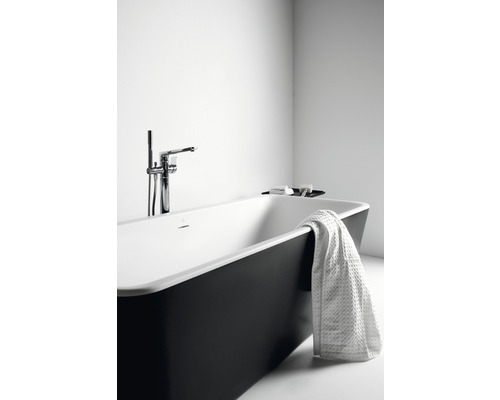 Freistehende Badewanne mit Armatur und Handtuch im Badezimmer.