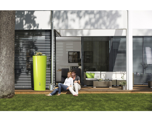 Szene im Garten mit einem Paar, einer Regentonne und einer Terrasse mit Gartenmöbeln