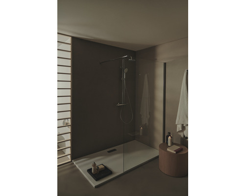 Ebenerdige Dusche mit Duscharmatur und Handtüchern in einem Badezimmer.