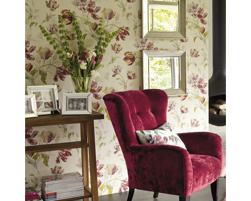 Wohnzimmer mit floraler Tapete, Sessel, Spiegeln, Tisch und Kamin