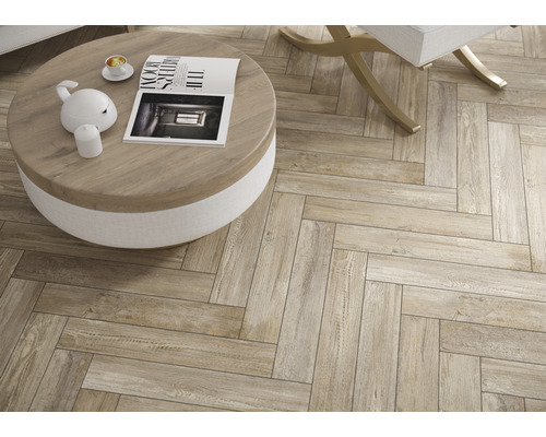 Ansicht eines Wohnzimmers mit einem Boden aus Holzoptikfliesen im Fischgrätmuster.