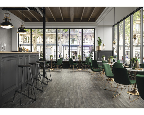 Innenraum eines Restaurants mit Bar, Stühlen, Tischen und großen Fenstern