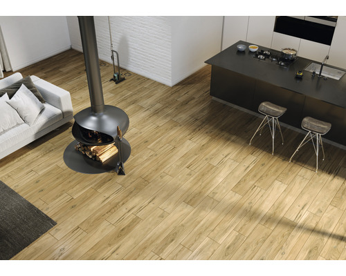 Heller Wohnraum mit Holzboden, Kaminofen, Sofa und Kücheninsel.