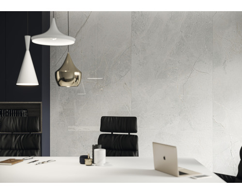 Büro mit Fliesenwand in Marmoroptik, Schreibtisch und Bürostuhl