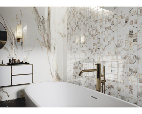 Helles Badezimmer mit Badewanne, Waschtisch und Fliesen in Marmoroptik