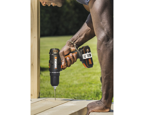 Ein Mann bohrt mit einem Akkuschrauber ein Loch in ein Holzbrett.