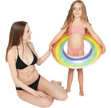 Mutter und Tochter mit aufblasbarem Schwimmreifen im Regenbogen Design