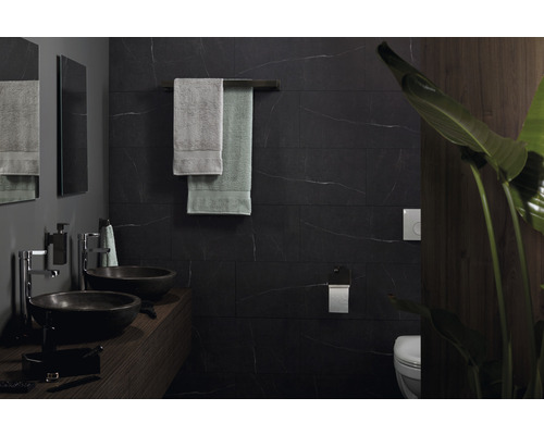 Modernes Badezimmer mit Waschbecken, Handtüchern und dunklen Fliesen