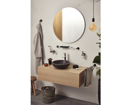 Modernes Badezimmer mit Waschtisch, rundem Spiegel, Handtuchhalter und Dekorationen