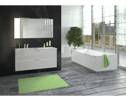 Badezimmer mit Waschtisch, Spiegel, Badewanne und Teppich