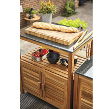 Grillwagen mit Schneidebrett, Zubehör und Lebensmitteln im Außenbereich.