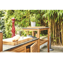 Outdoor-Küche mit Arbeitsplatten, Schränken und Regalen vor natürlichem Hintergrund.