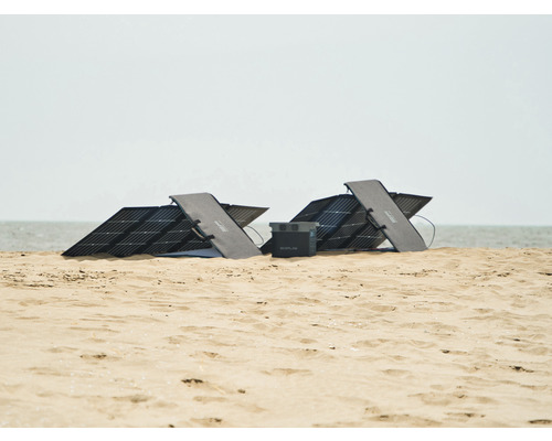 Zwei Solarmodule und ein Akku auf einem Sandstrand