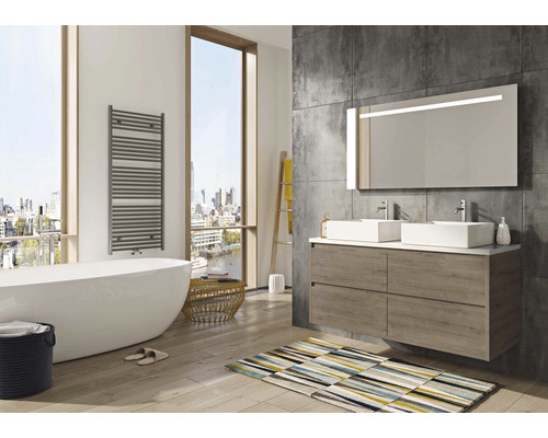 Helles Badezimmer mit Badewanne, Waschbeckenunterschrank, Spiegel und Handtuchwärmer.