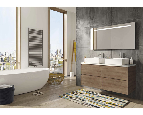 Helles Badezimmer mit Badewanne, Waschtisch mit zwei Waschbecken und beleuchtetem Spiegel