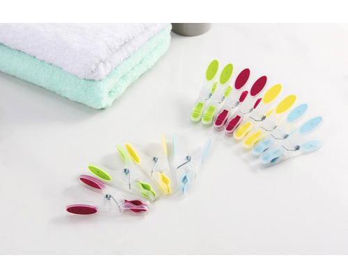 Mehrfarbige Wäscheklammern neben Handtüchern