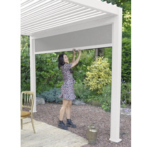 Frau bedient eine Pergola mit Rollo im Garten.