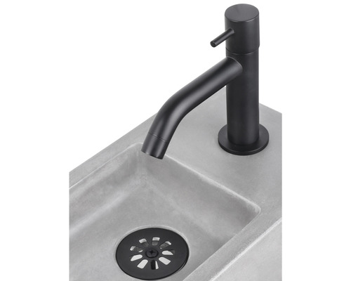 Waschtischarmatur in Schwarz auf einem Betonwaschbecken mit Ablaufgarnitur