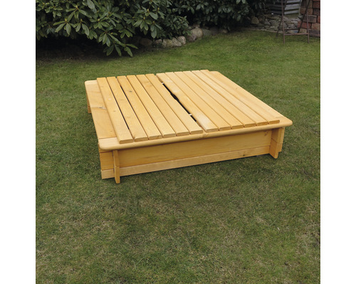 Sandkasten aus Holz mit teilweise geschlossenem Deckel auf Rasen