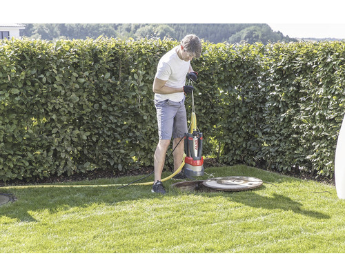 Mann bedient eine Schmutzwasserpumpe von Al-Ko im Garten