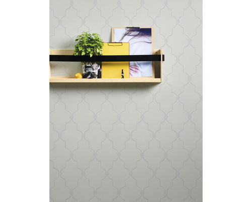 Wand mit floral gemusterter Tapete und einem Regal mit Dekoration