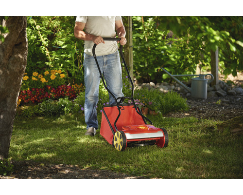 Eine Person benutzt einen Rasenlüfter im Garten.