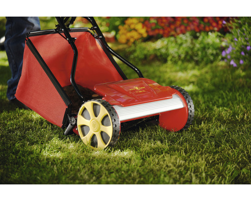 Handrasenmäher mit Grasfangkorb auf Rasen