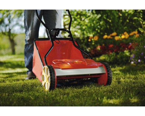 Handrasenmäher mit Fangkorb auf Rasen