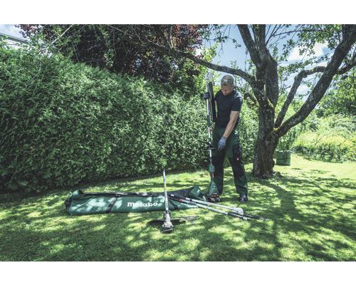 Mann montiert Metabo Multifunktionsgerät im Garten.