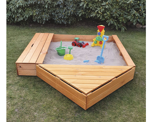 Sandkasten aus Holz mit Spielzeug im Garten