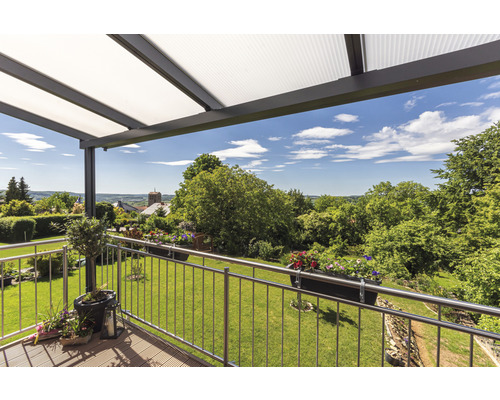 Überdachte Terrasse mit Blick auf einen Garten und eine Landschaft